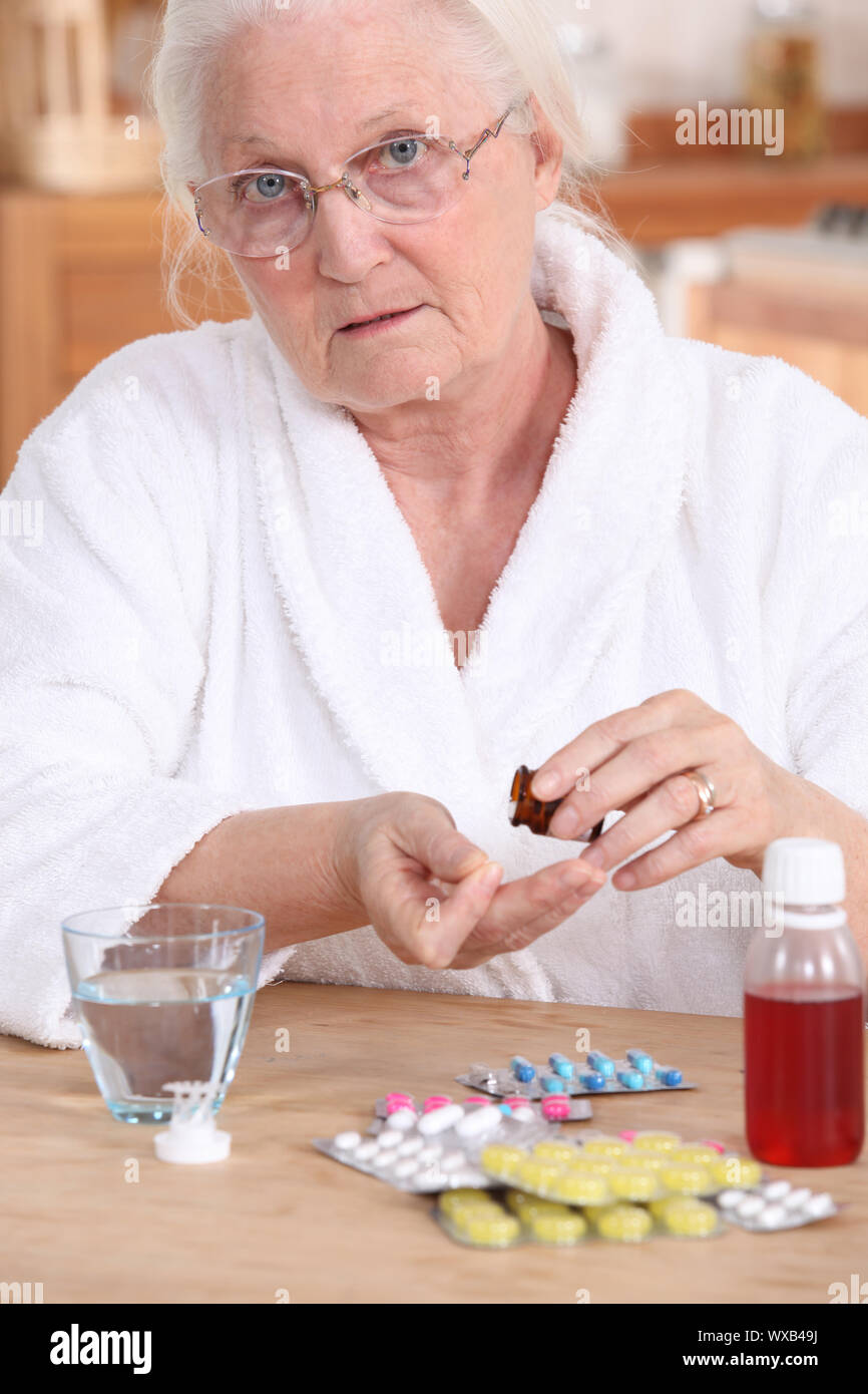 Older woman taking medicine Stock Photo