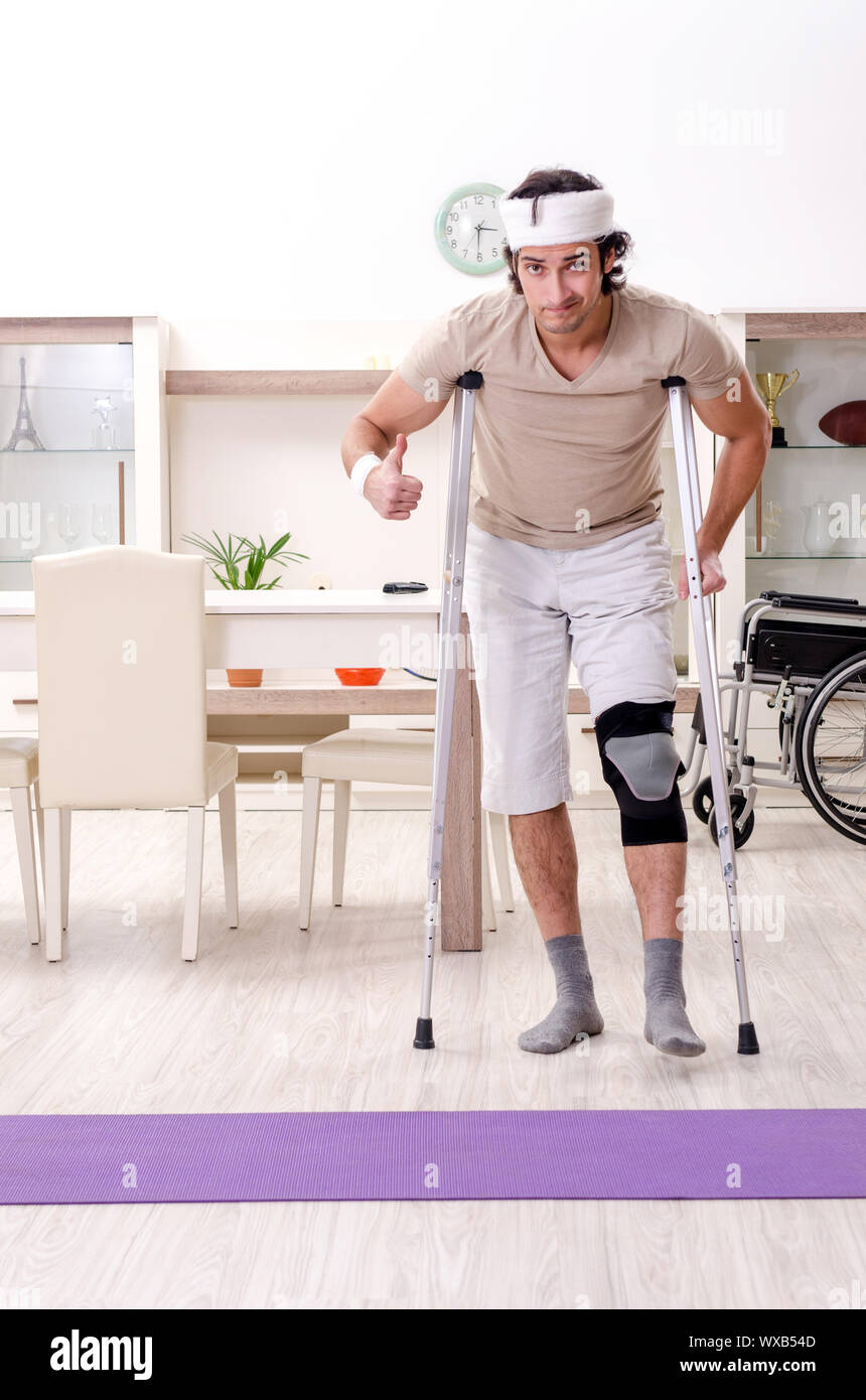 Injured young man doing exercises at home Stock Photo - Alamy