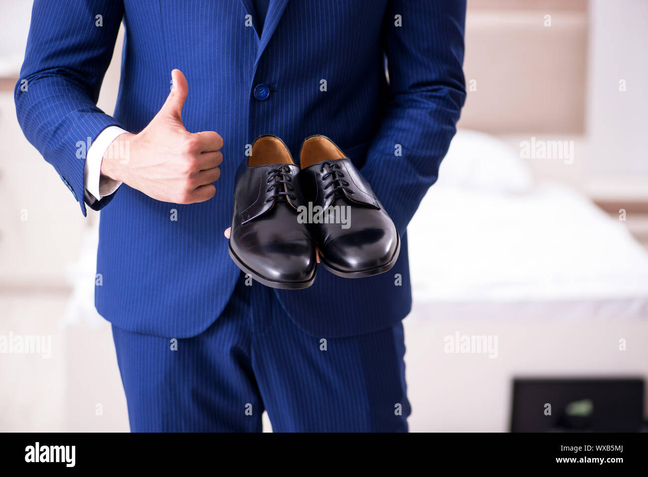 Young handsome businessman choosing shoes at home Stock Photo