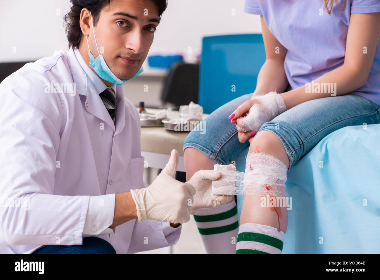 Leg injured young woman visiting male doctor Stock Photo