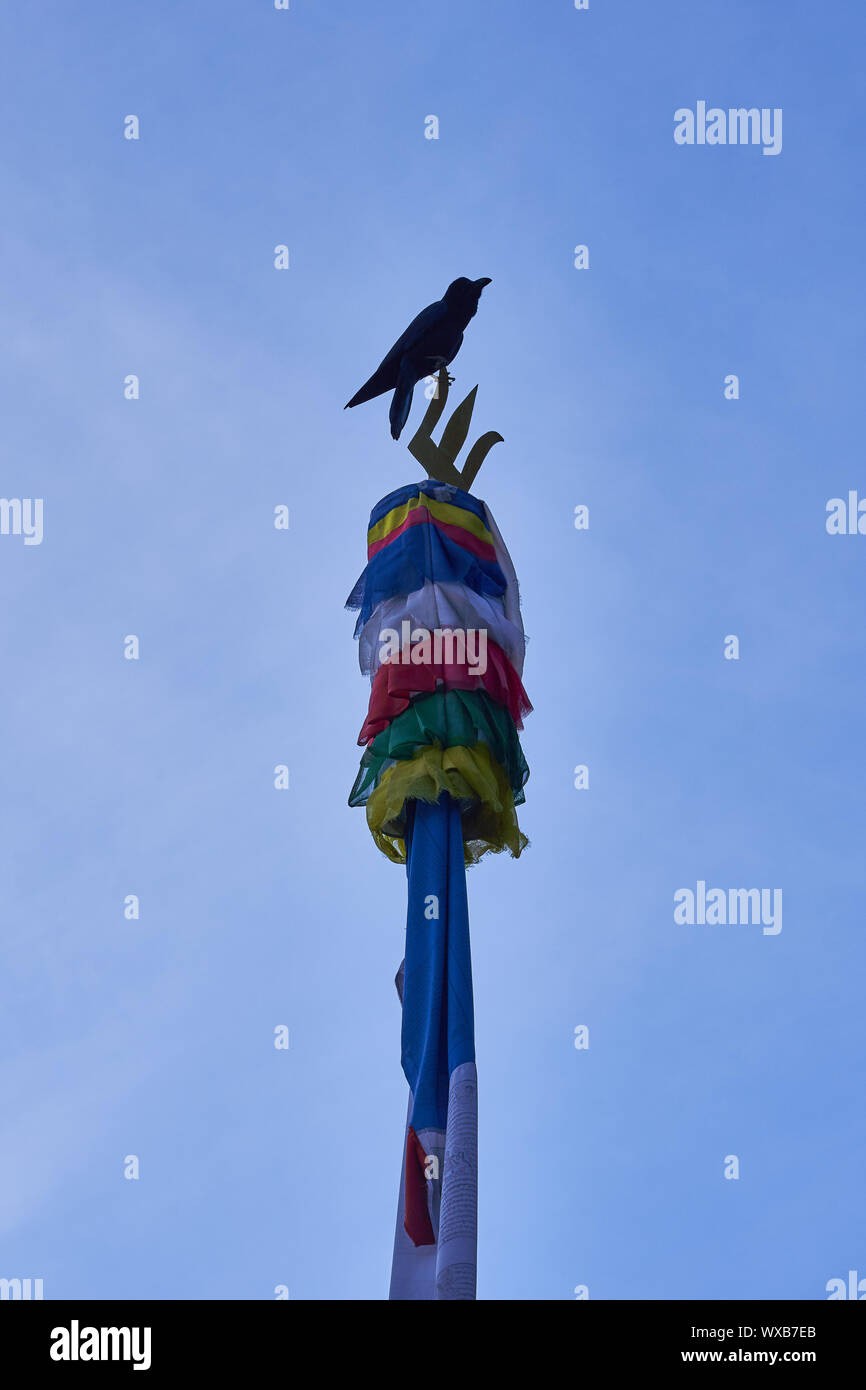 Bird sitting on prayer flag Stock Photo