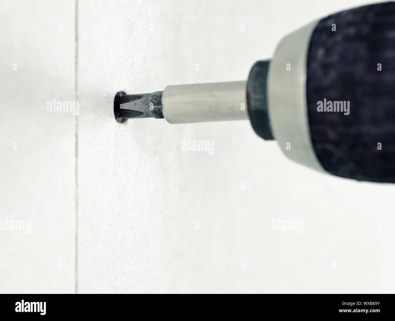 Driving a screw into drywall Stock Photo Alamy