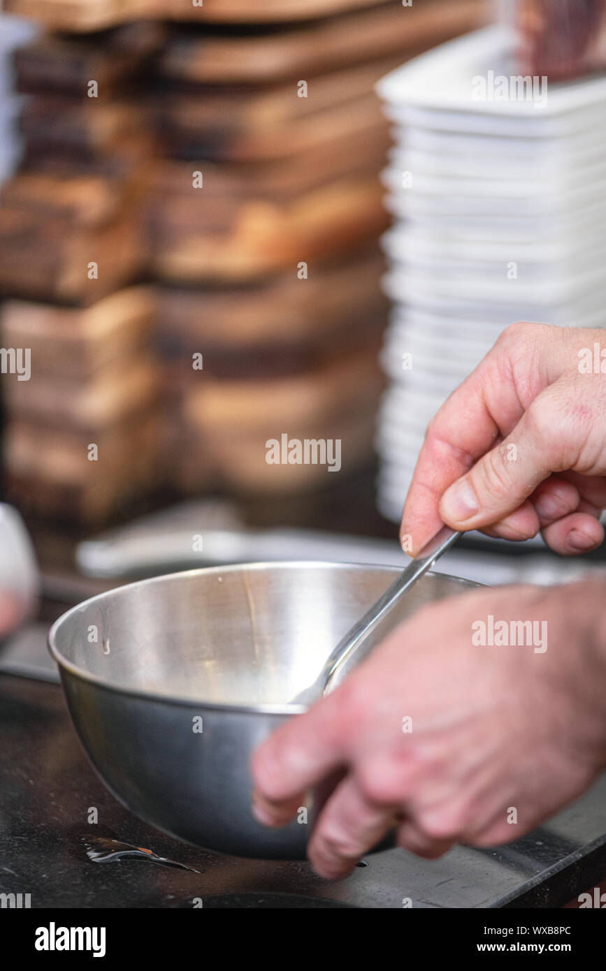 Chef hands beating eggs in a bowl . Stock Photo
