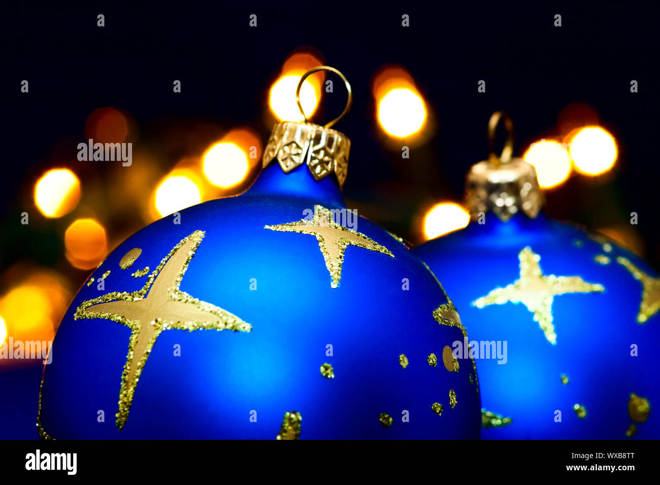 Christmas blue baubles with blurred lights in background, shallow DOF Stock Photo