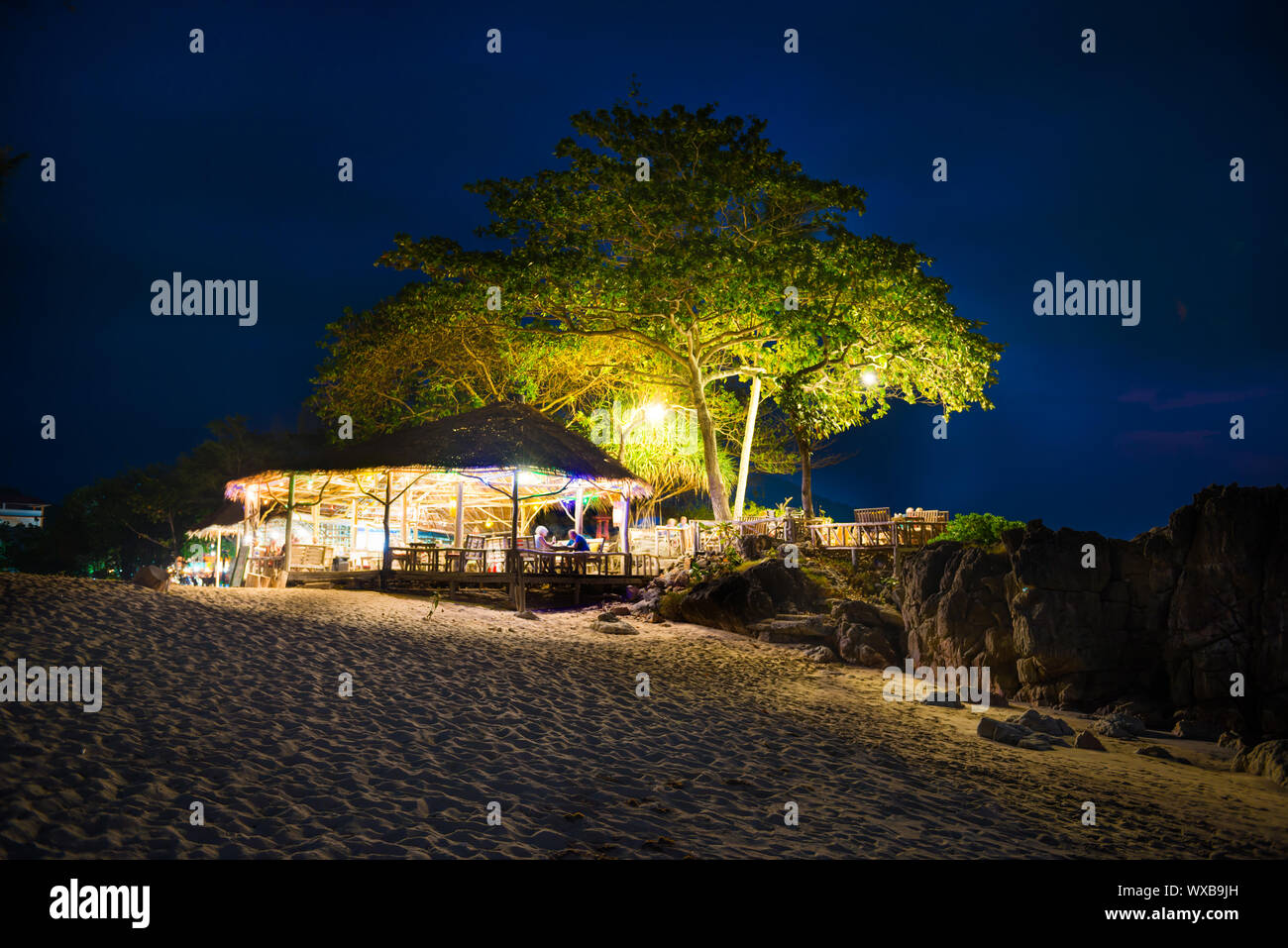 Restaurant at sand beach on blue night sky background Stock Photo