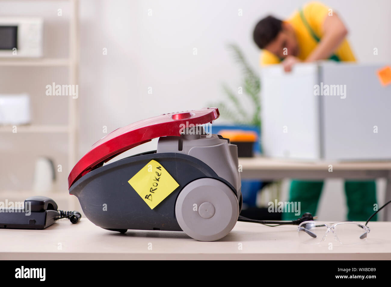 Man repairman repairing vacuum cleaner and fridge Stock Photo Alamy