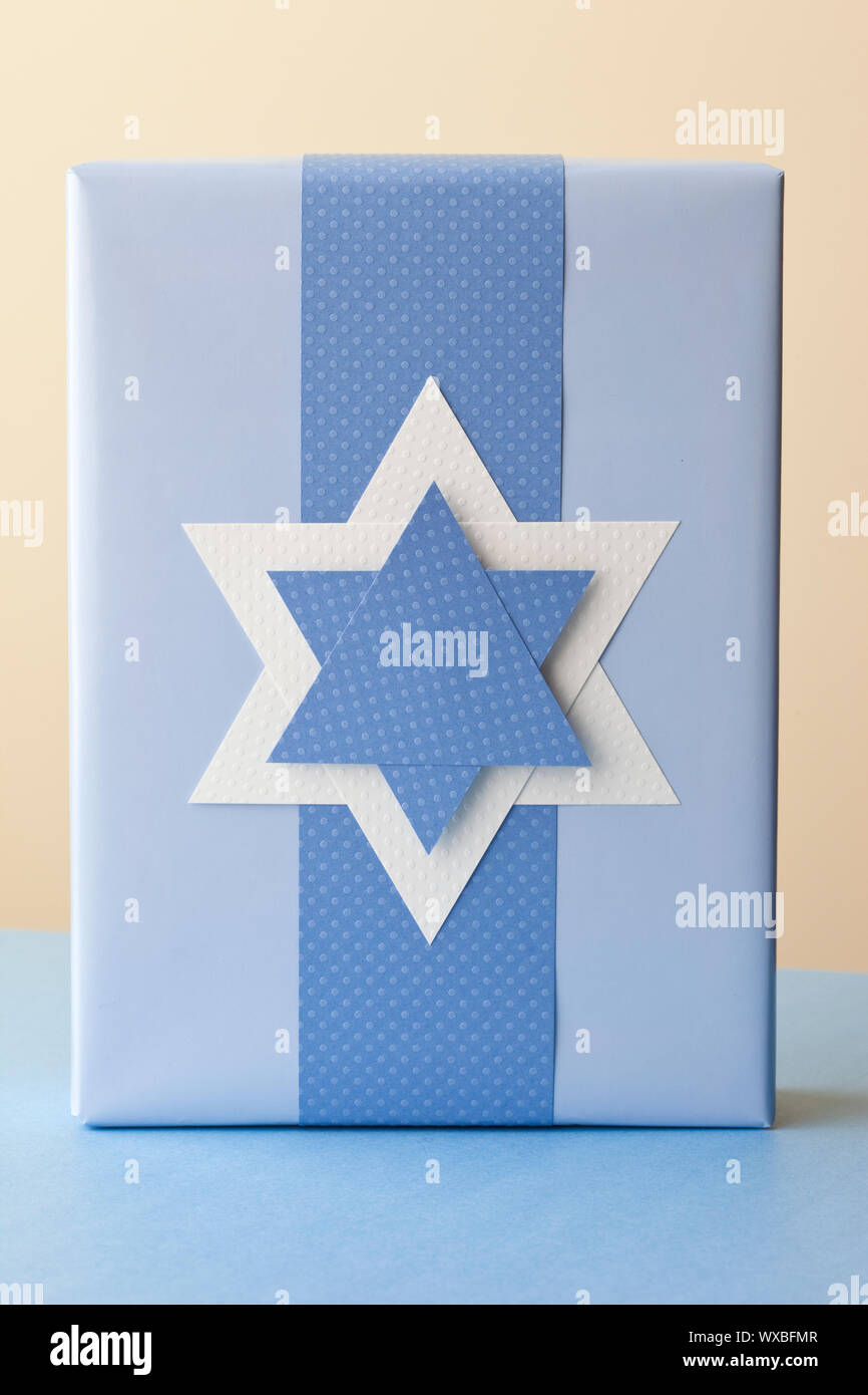 Hanukkah gift present with handmade Star of David decoration. Jewish holiday traditions paper crafts. Stock Photo