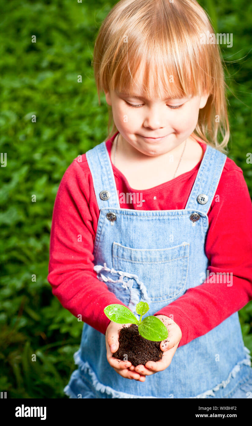 Little girl holding seeding with ground Stock Photo