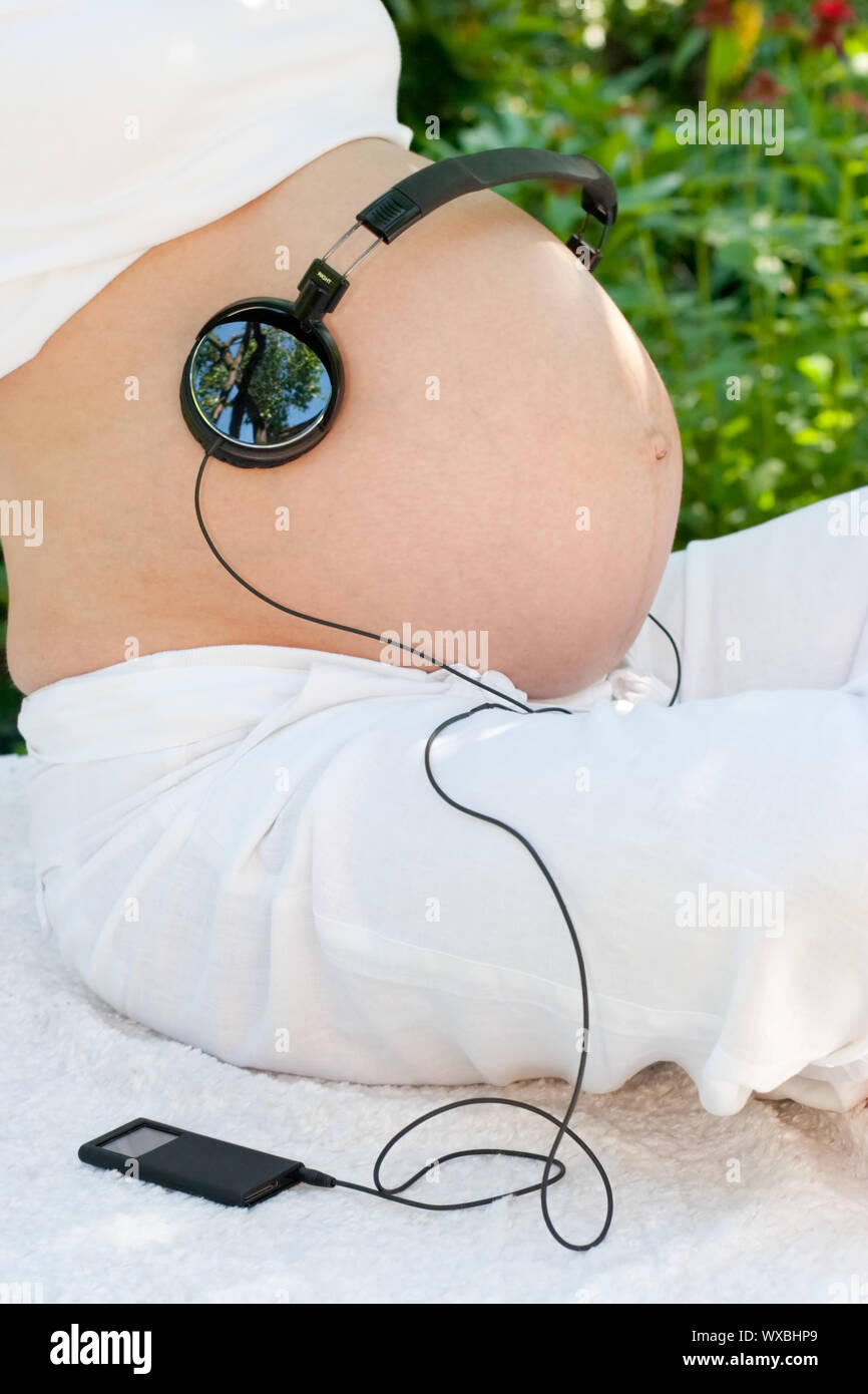 Headphones on a pregnant woman's belly Stock Photo Alamy