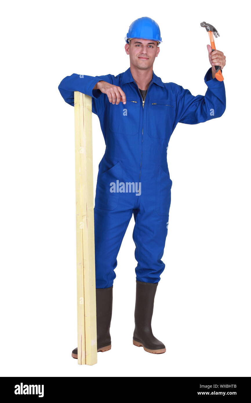 A male carpenter with a hammer and a plank. Stock Photo