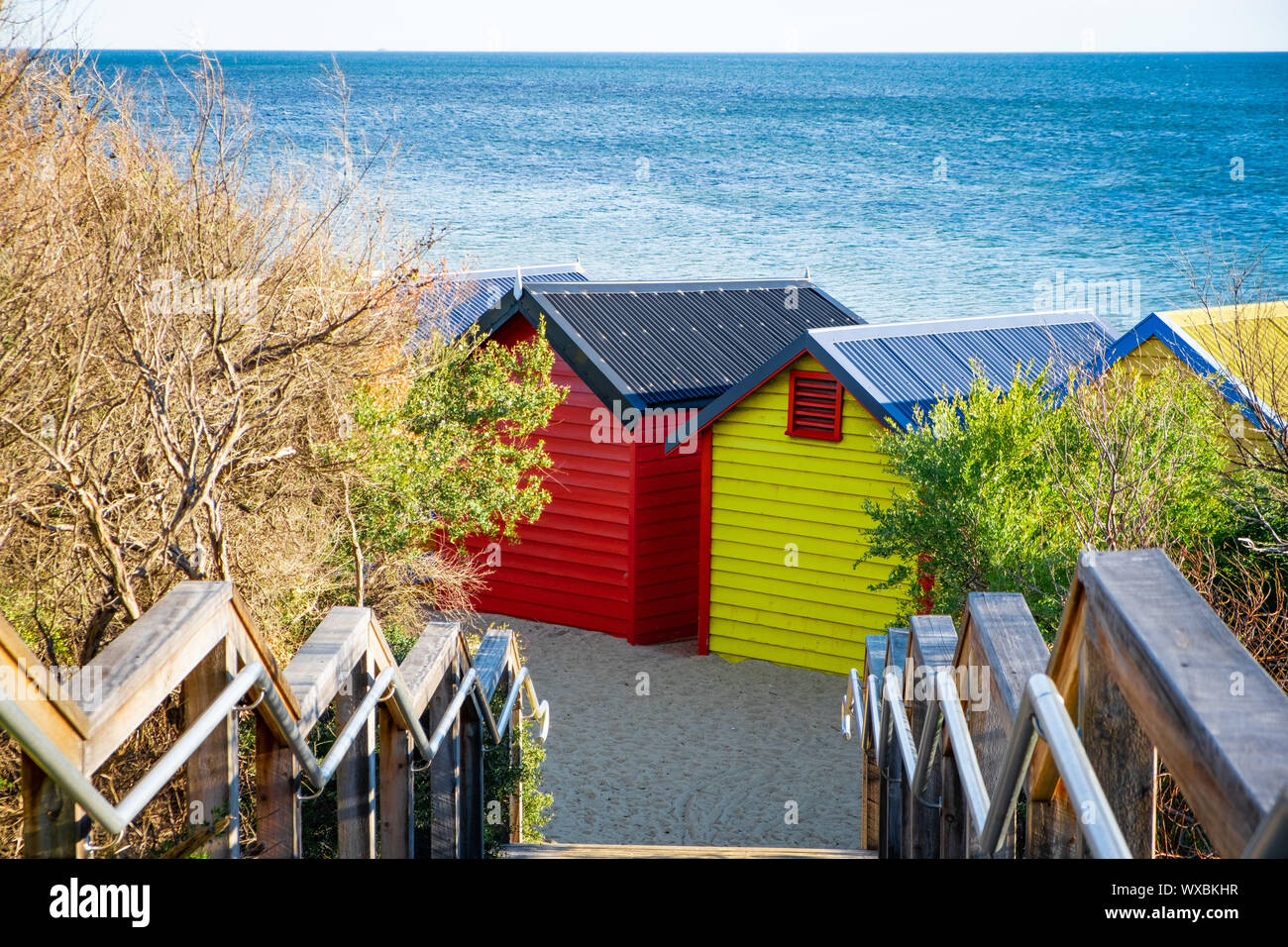 Colorful Brighton Beach huts against blue sea in bright daylight. Melbourne, Victoria, Australia Stock Photo