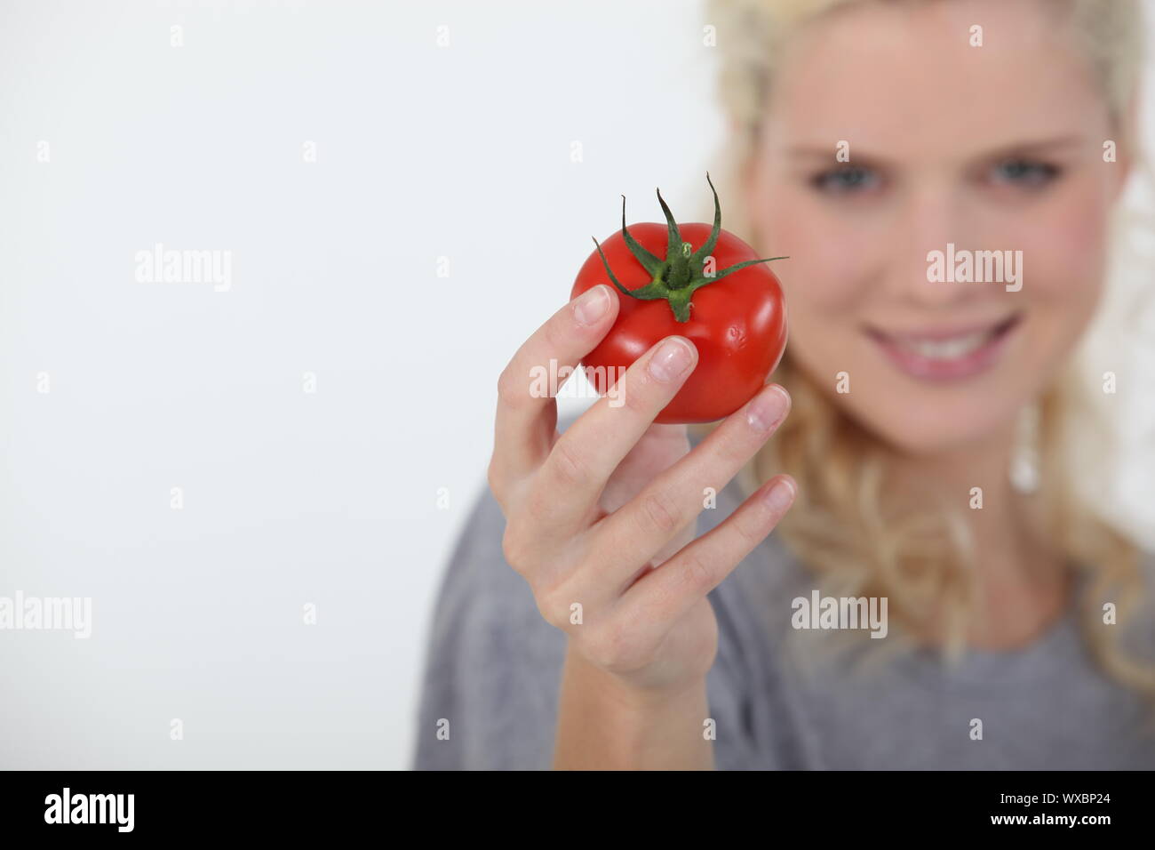 Woman holding a tomato Stock Photo - Alamy