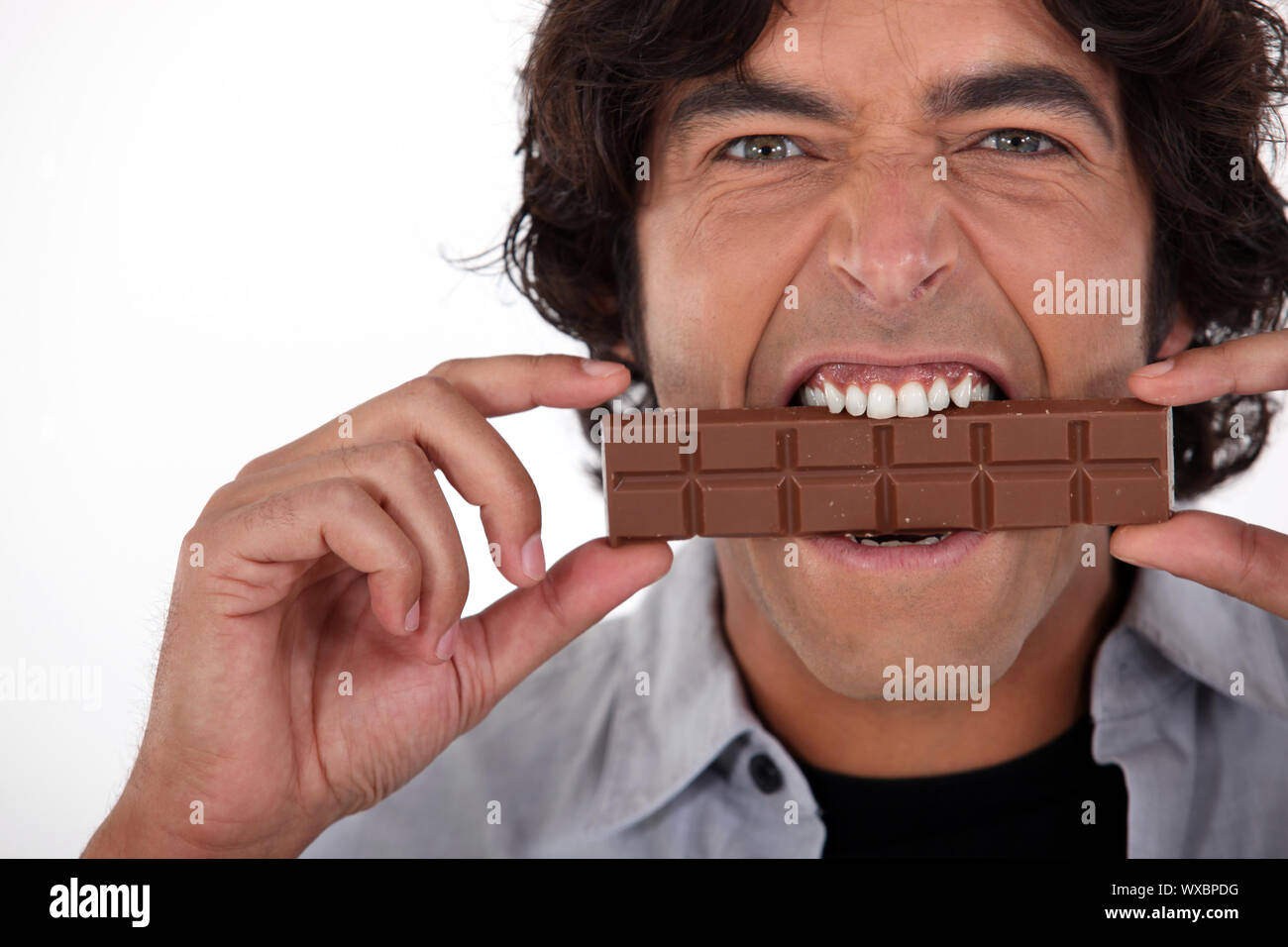 Man playfully eating chocolate Stock Photo