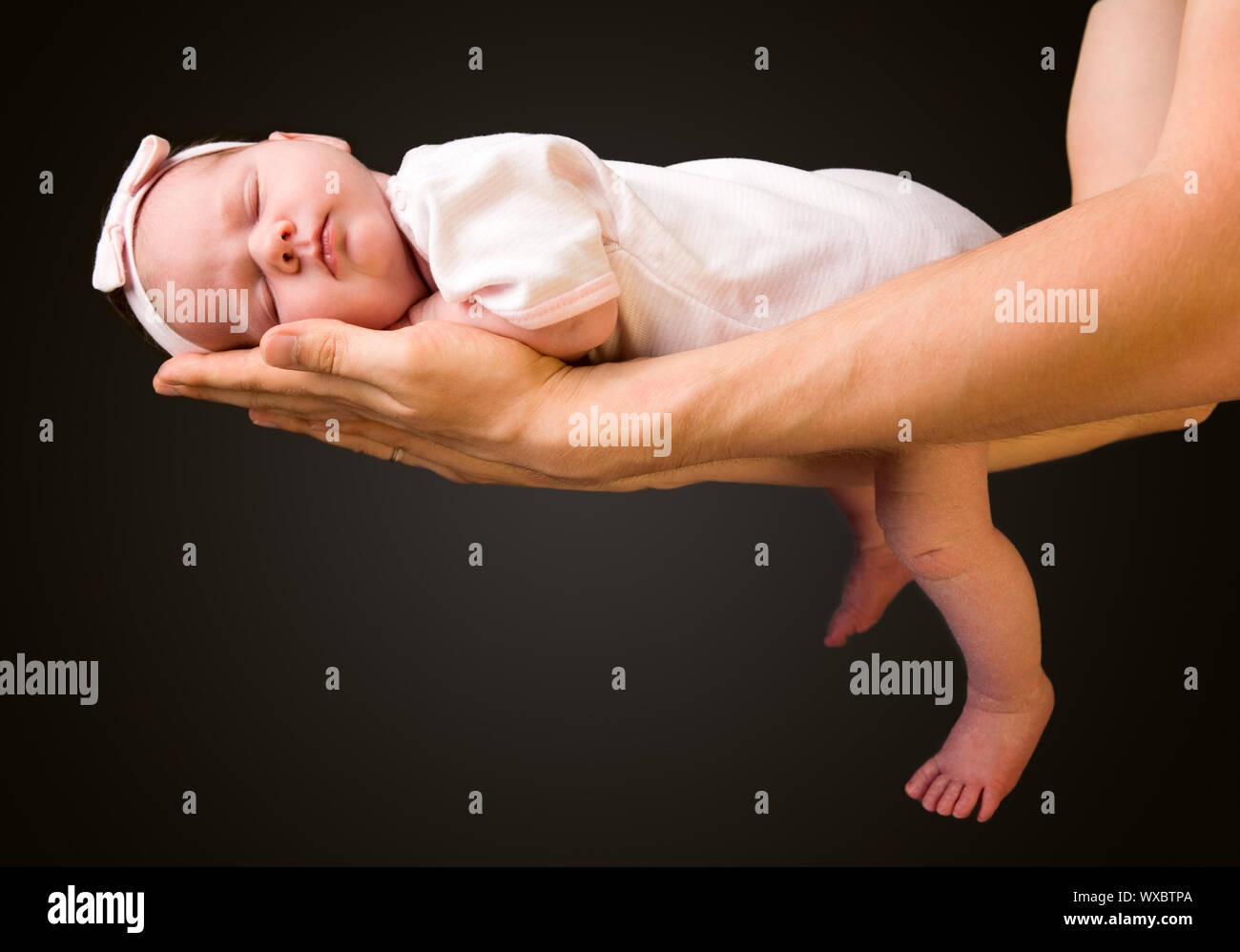 Supporting Hands. Father holding his 14 days old baby girl on his arms