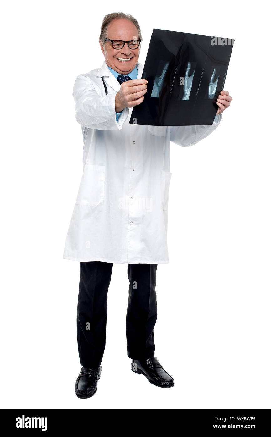 Senior medical practitioner looking at the x ray sheet and smiling. Stock Photo
