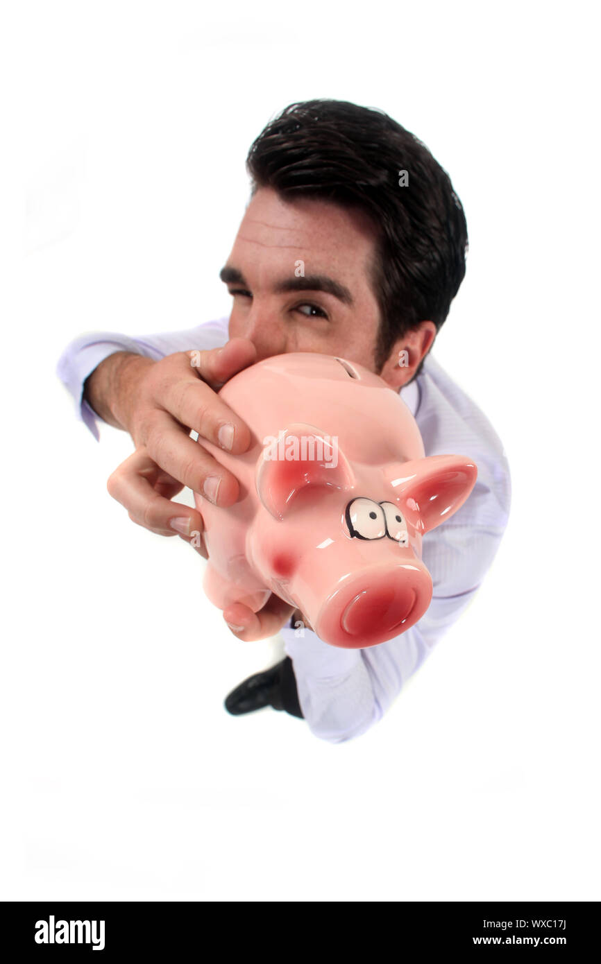 Man standing on white background showing piggy bank Stock Photo - Alamy
