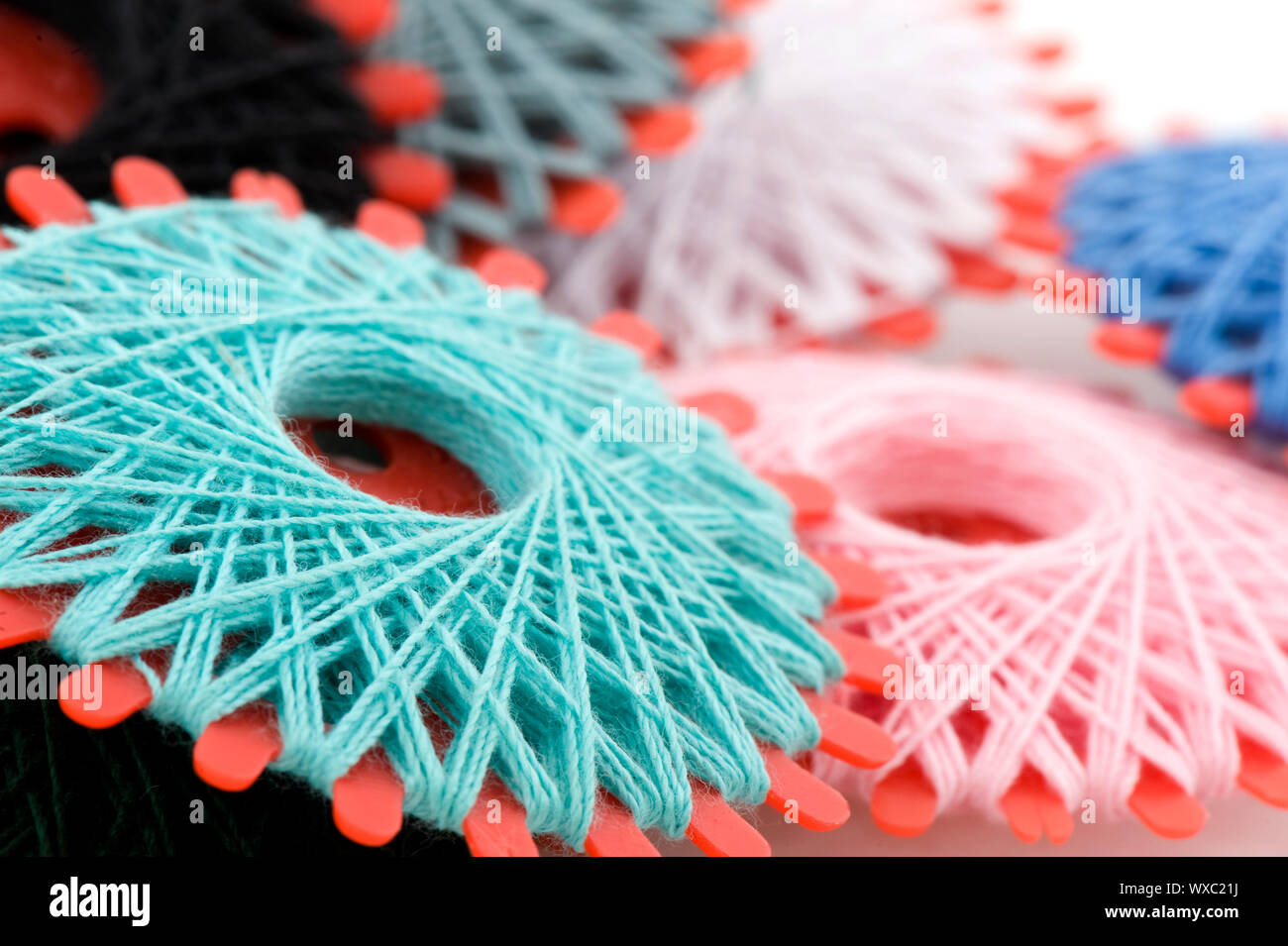 Many bobbins with different colored threads for sewing Stock Photo