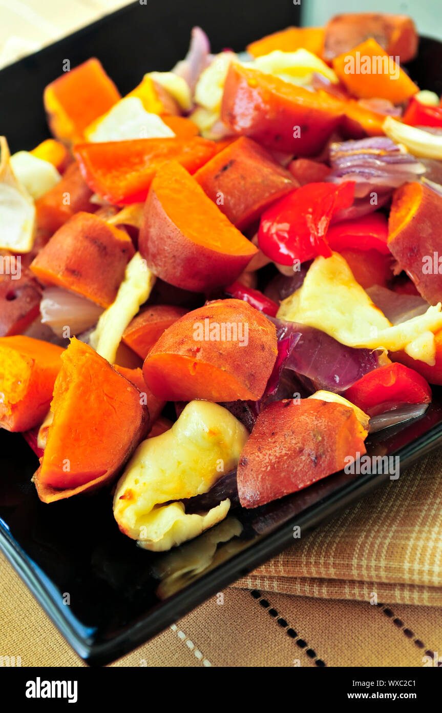 Vegetarian dish of roasted yams with cheese and peppers Stock Photo