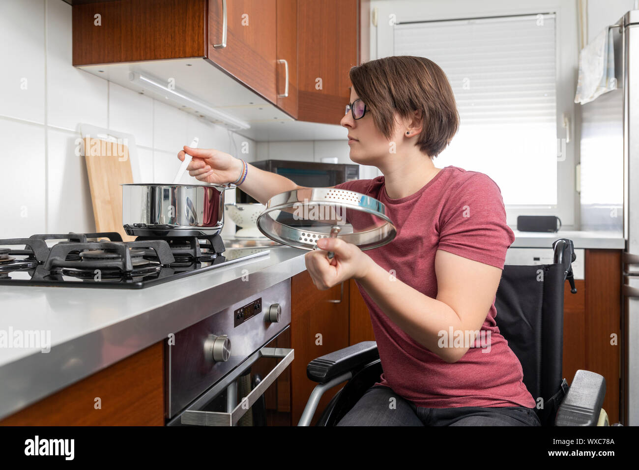 disabled woman cooking in the kitchen Stock Photo