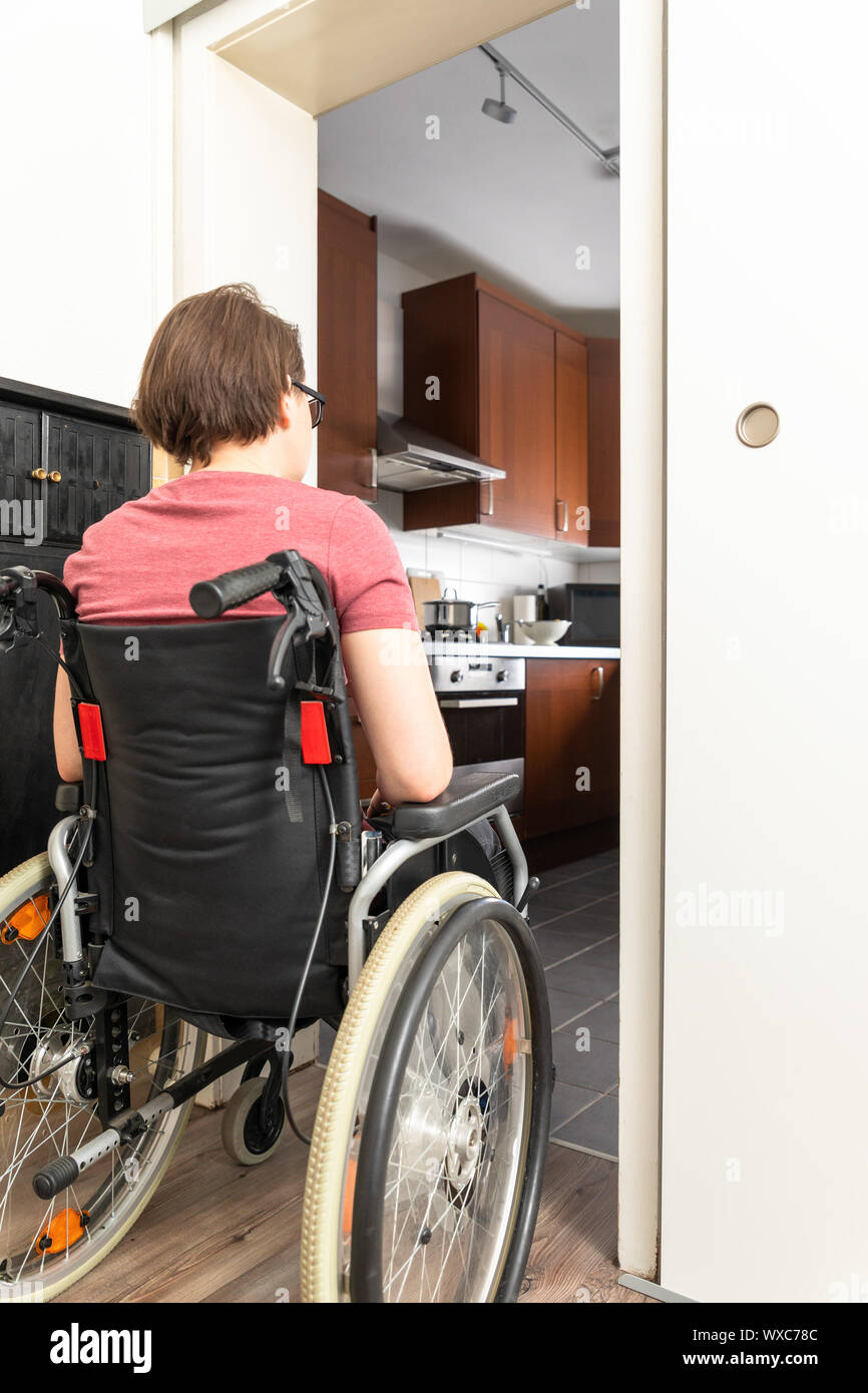 disabled woman at the open door to the kitchen Stock Photo