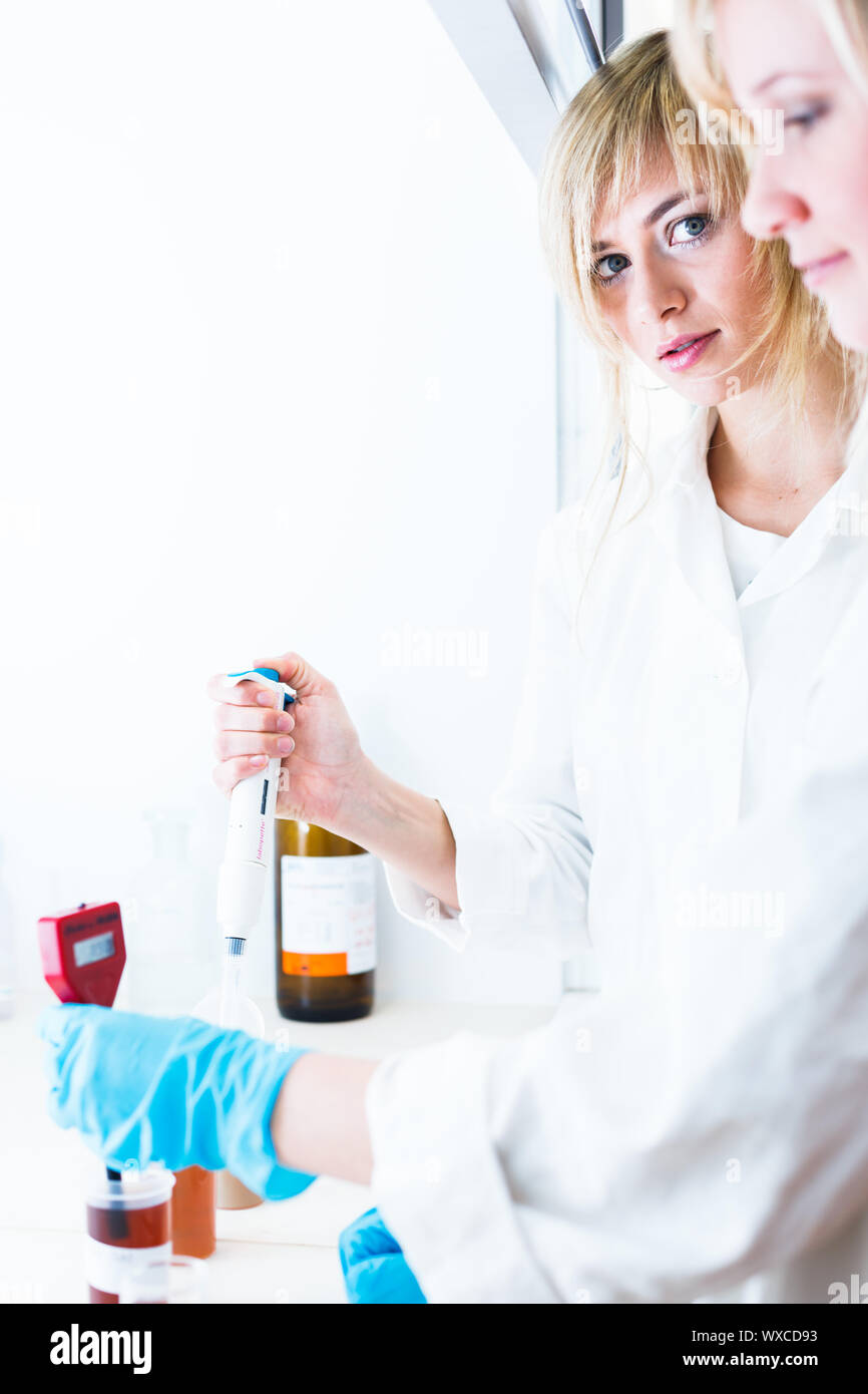 Two female researchers working in a laboratory (color toned image Stock
