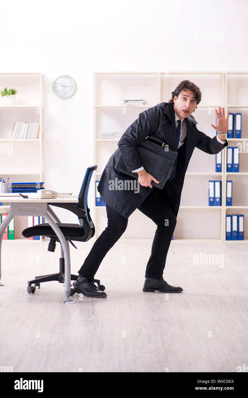 Young male employee in the office in time management concept Stock Photo