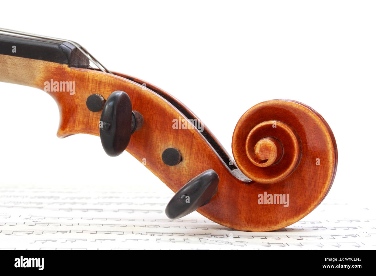 Violin scroll on sheet music Stock Photo Alamy