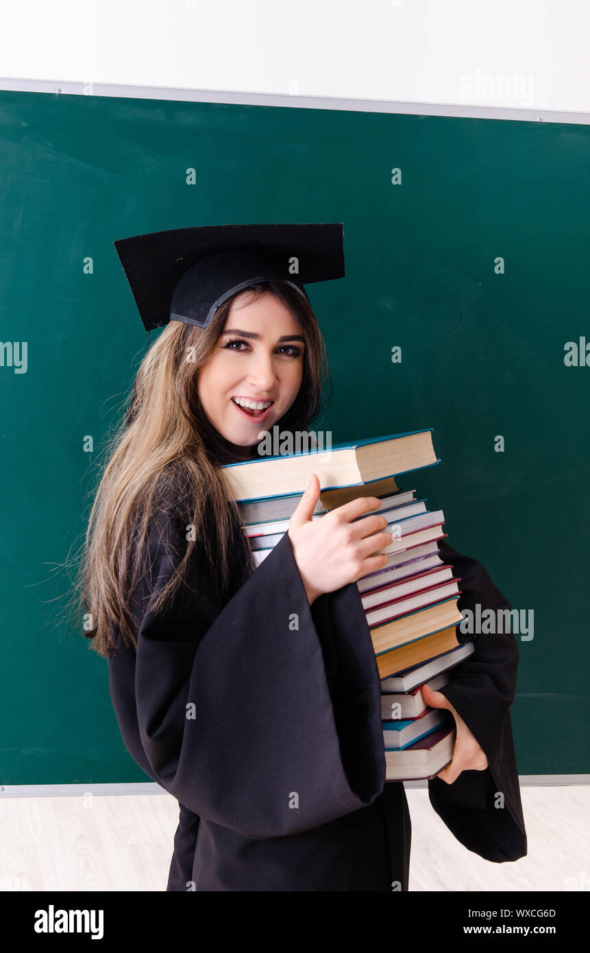 Female graduate student in front of green board Stock Photo - Alamy