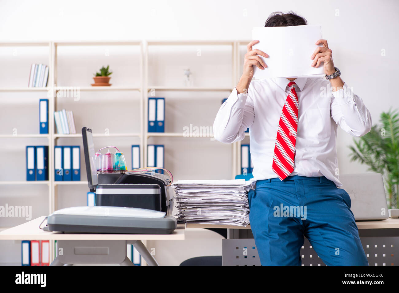 Young employee making copies at copying machine Stock Photo - Alamy