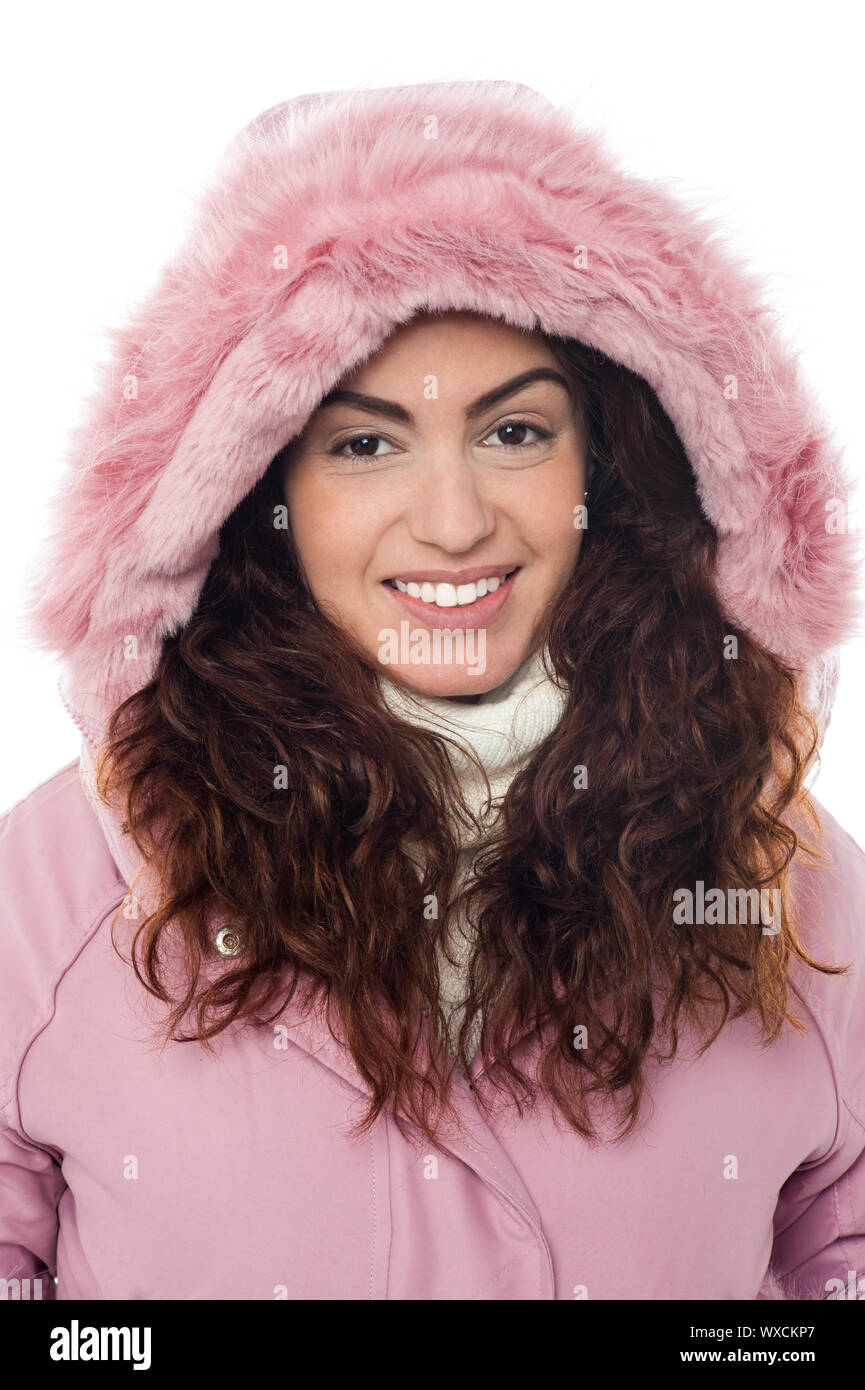 Closeup shot of permed hair woman wearing pink winter jacket with a hood. Stock Photo