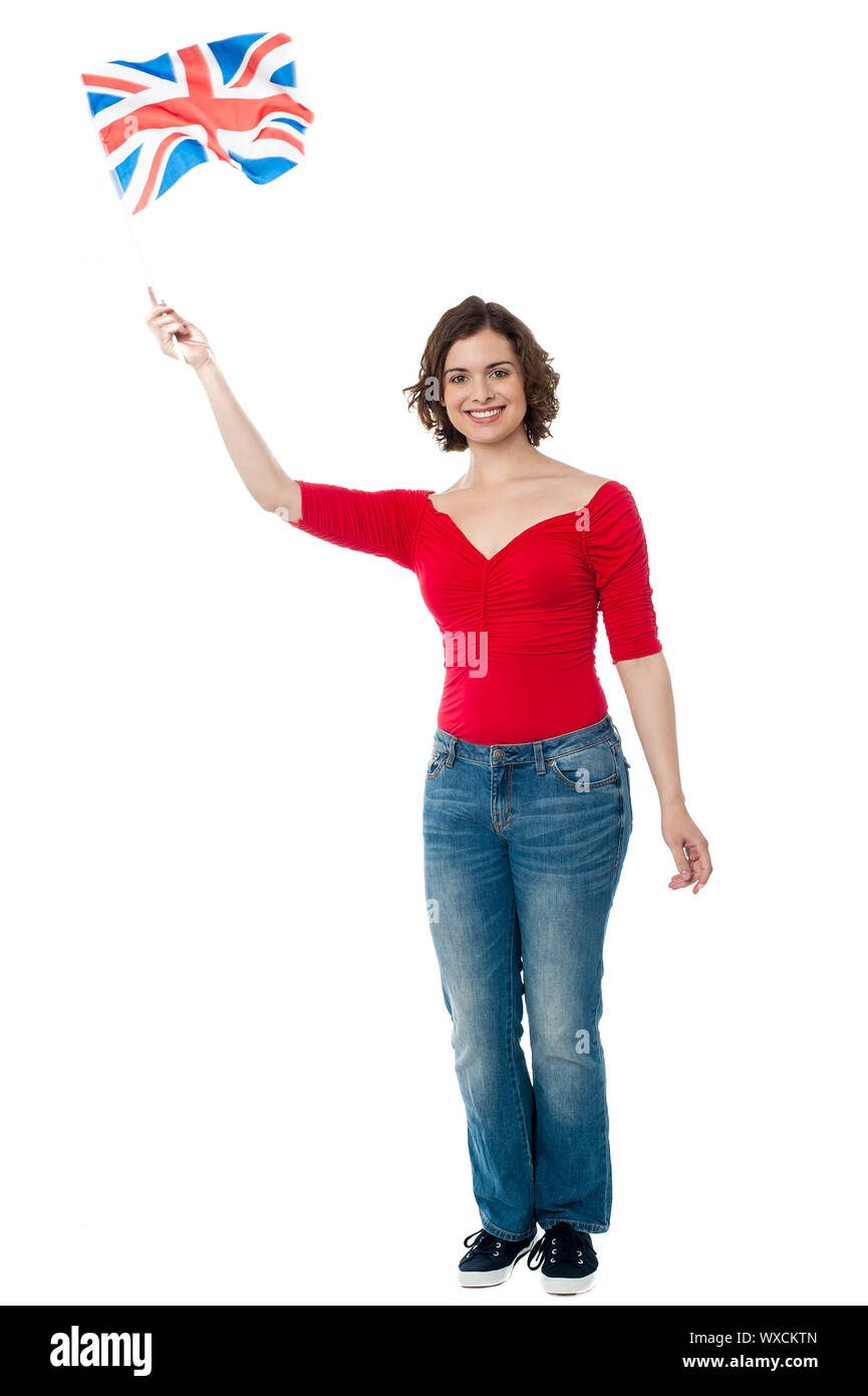 Full length portrait of a patriotic woman waving national flag. Stock Photo