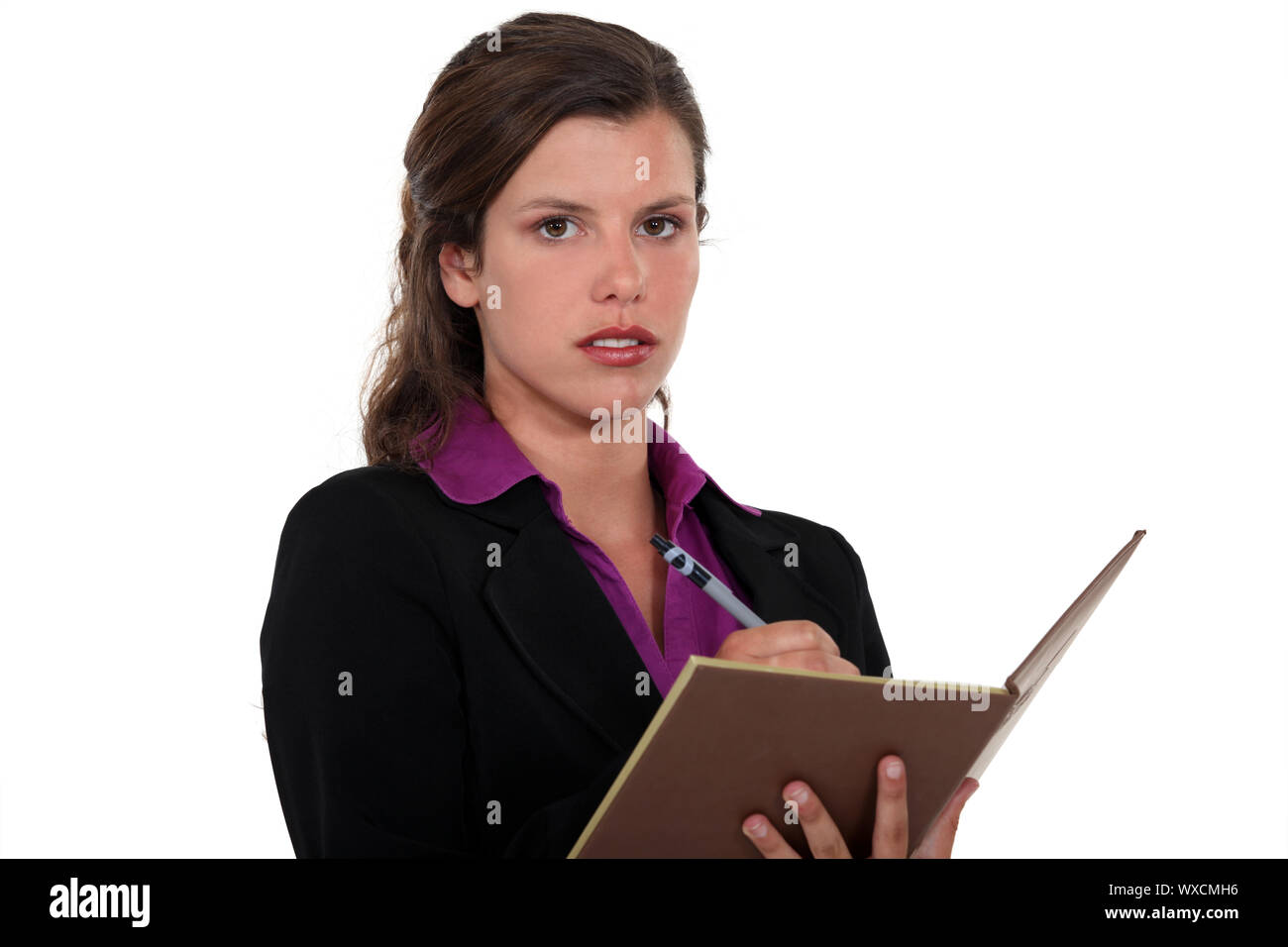 Businesswoman writing in her agenda Stock Photo