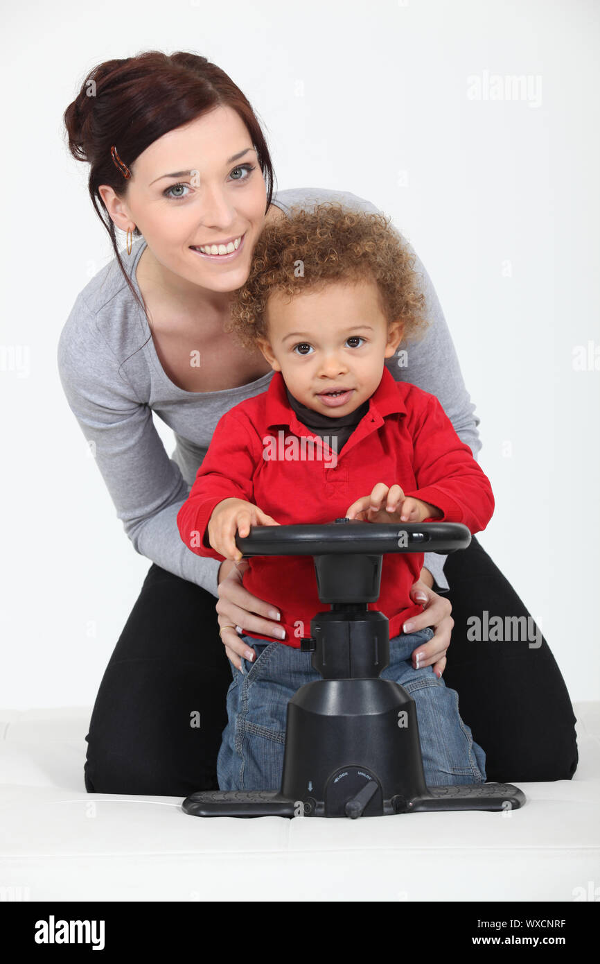 Woman and child playing with a toy steering wheel Stock Photo Alamy