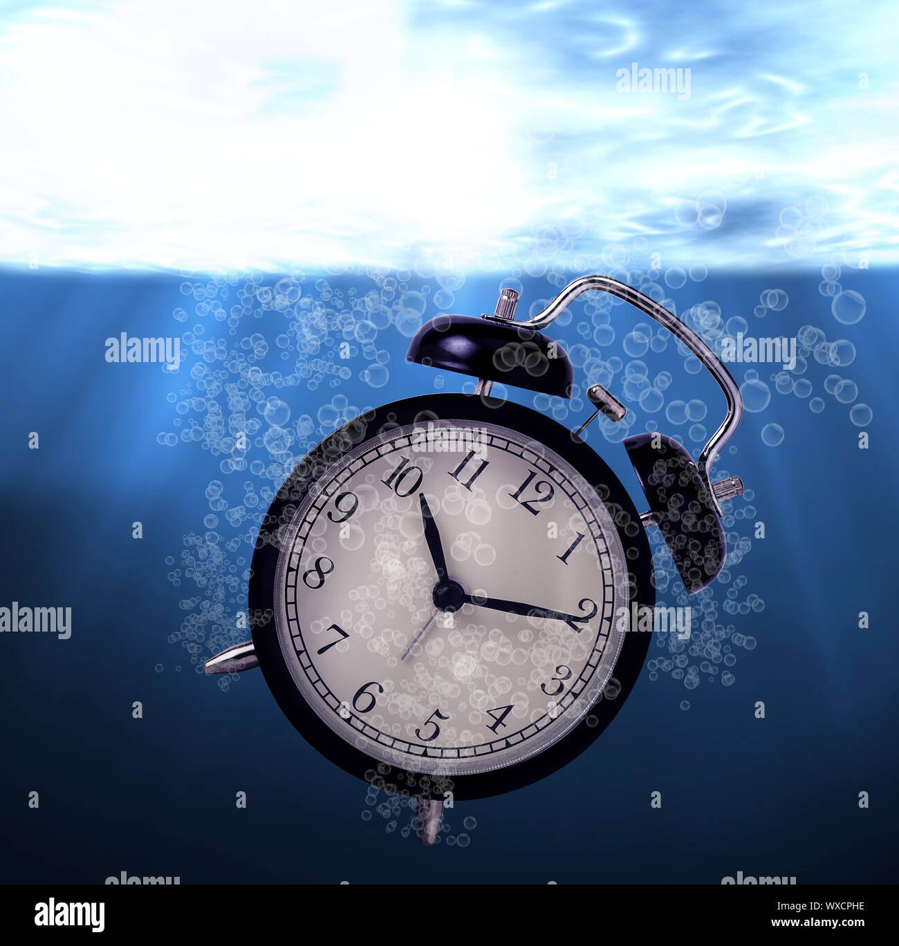Waste of time concept, drowning alarm clock Stock Photo