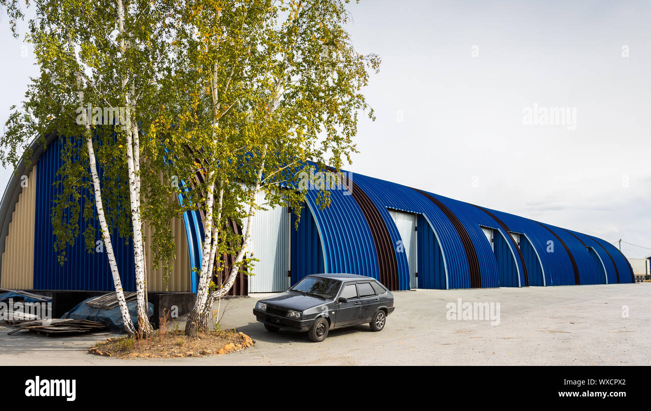 Facade on large industrial building made of metal white and blue panels ...