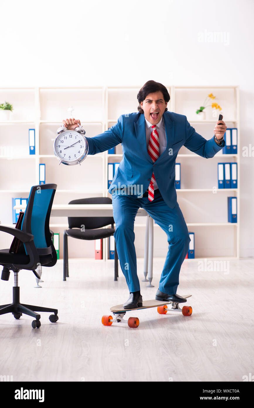 Young handsome businessman with longboard in the office Stock Photo - Alamy