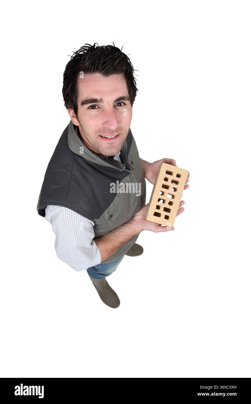 Handyman holding a brick Stock Photo Alamy