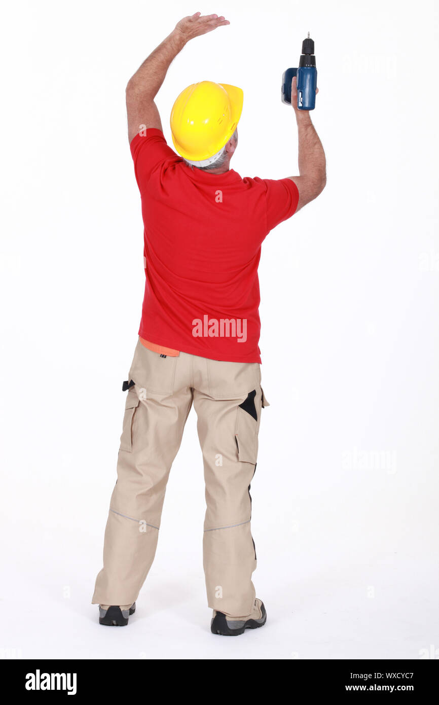 A handyman drilling the ceiling. Stock Photo