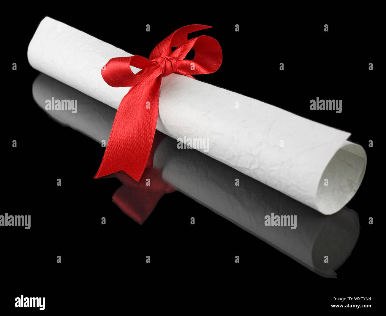 Diploma with a red silk ribbon, isolated on black background Stock