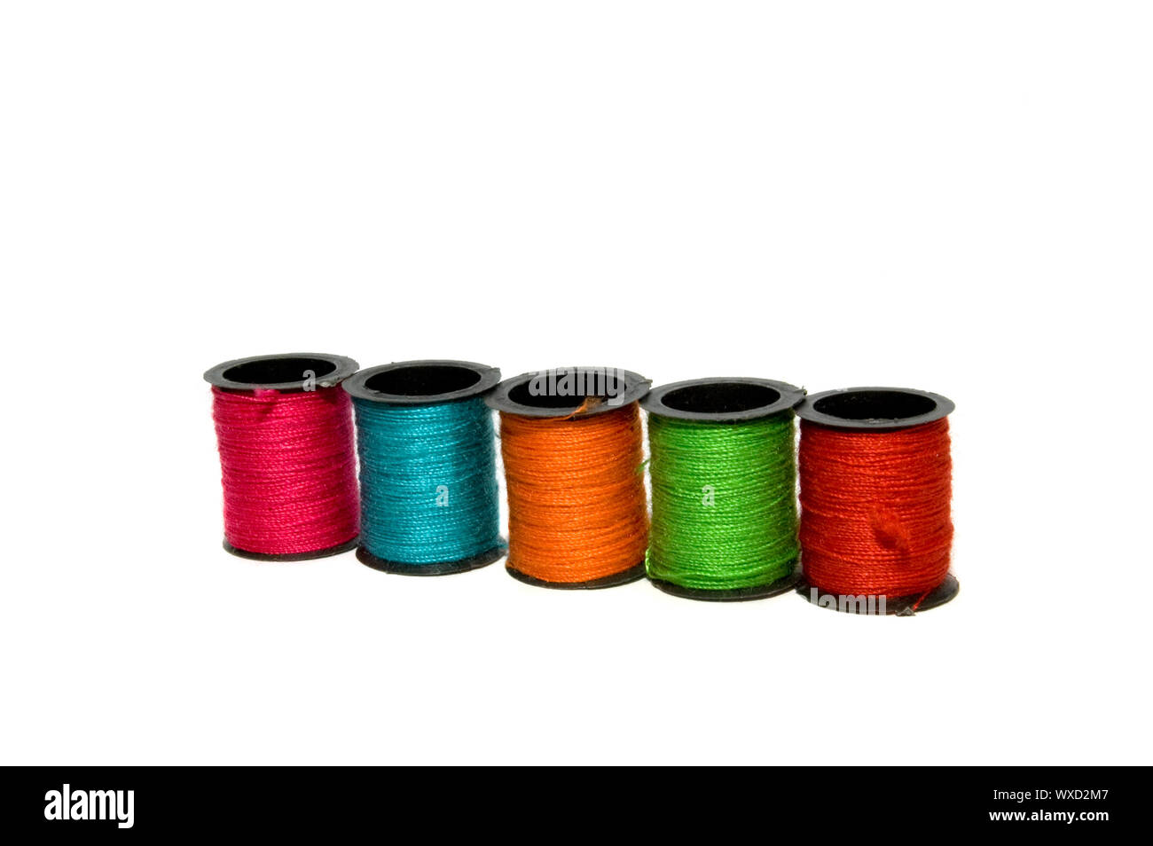 Five different colours of spools of thread Stock Photo