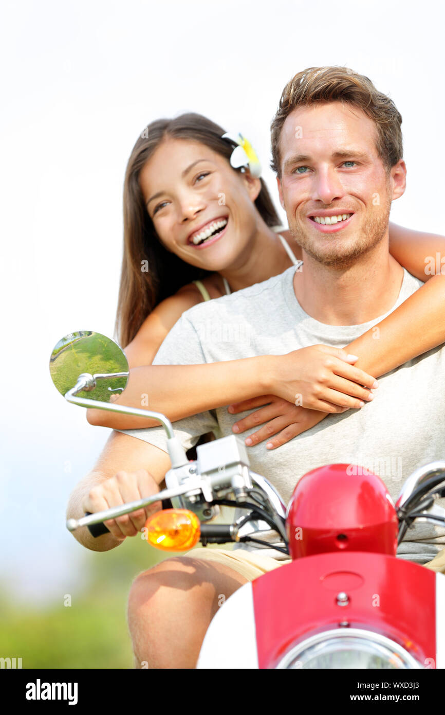 Young couple on scooter in love. Joyful mixed race couple having fun ...