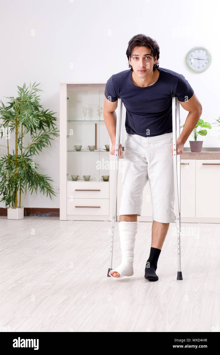 Leg injured young man suffering at home Stock Photo - Alamy