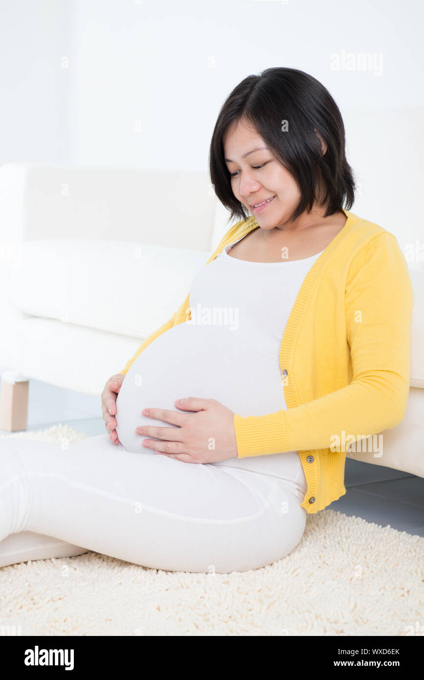 Portrait Of An Attractive Pregnant Asian Chinese Woman Touching