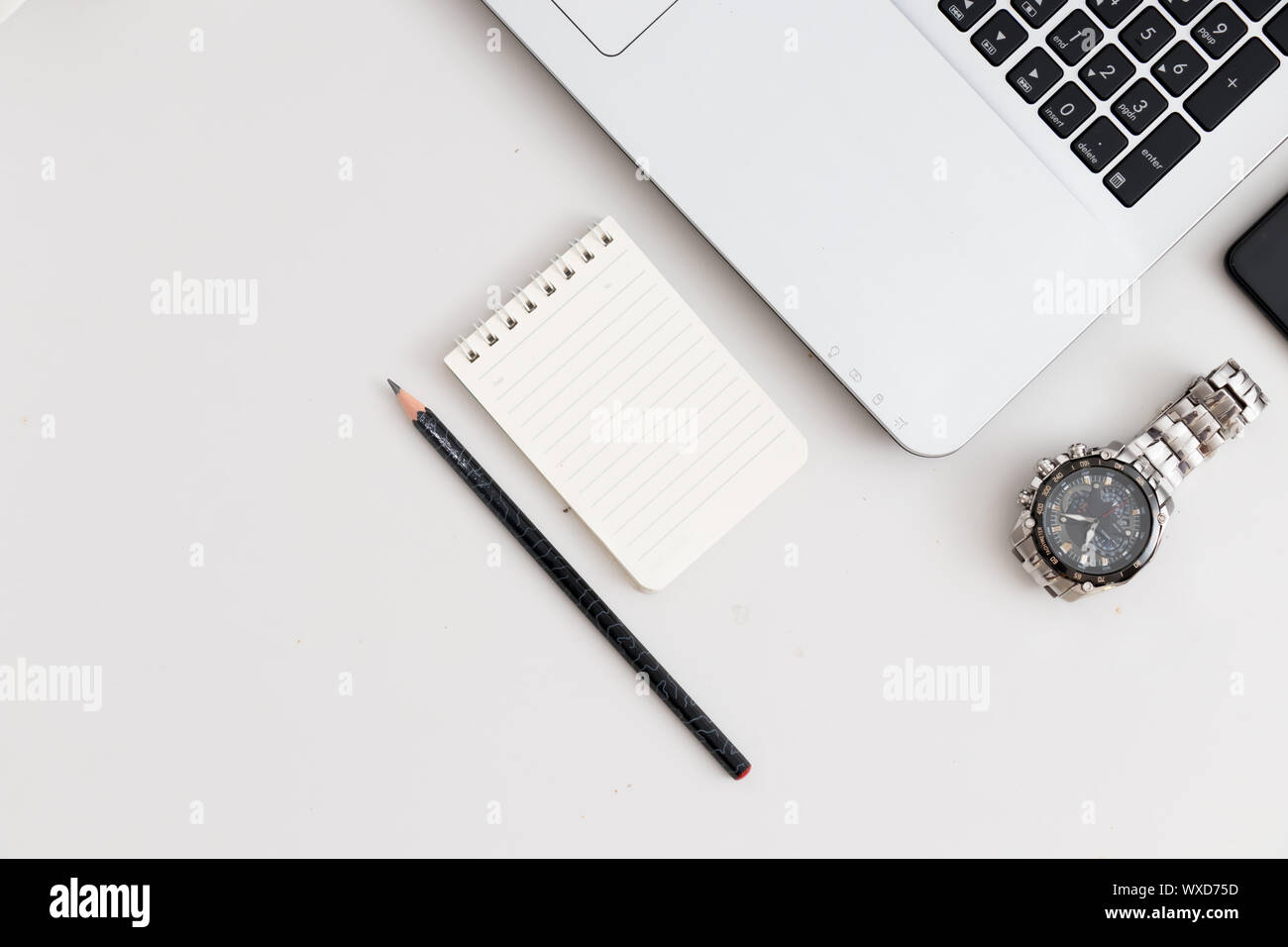 White office desk with laptop watch, notebook with pen Stock Photo - Alamy
