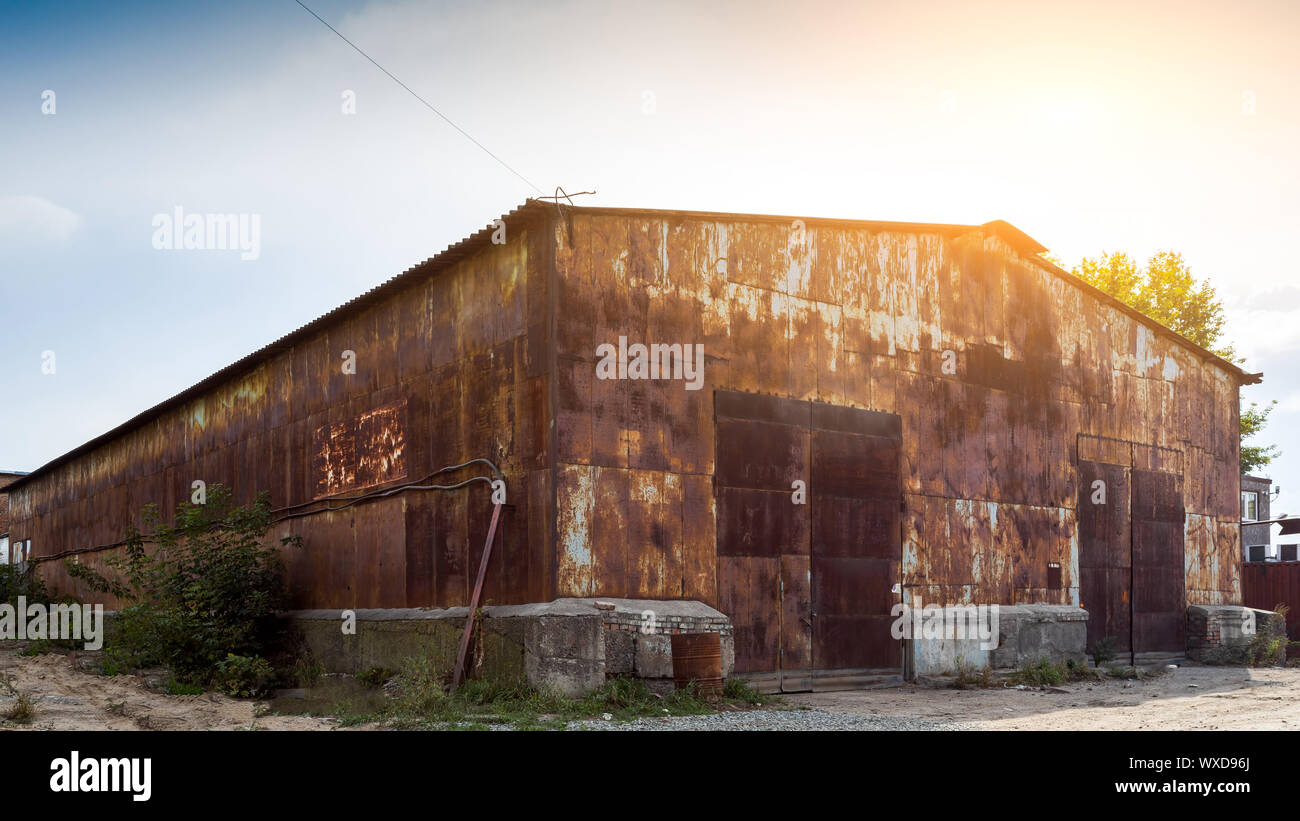 Old brown warehouse with sheet metal cladding with street lights