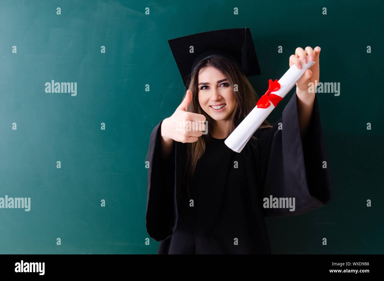 Graduate Front Use Female graduate student in front of green board Stock Photo - Alamy