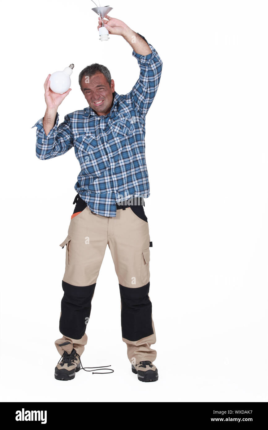 electrician fixing a bulb and having an electric shock Stock Photo