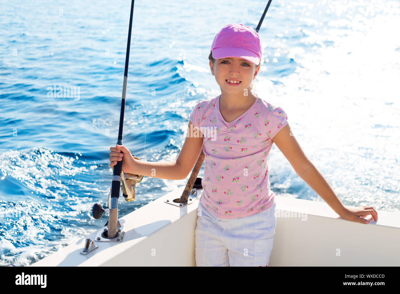child girl sailing in fishing boat holding rod in blue sea Stock Photo ...