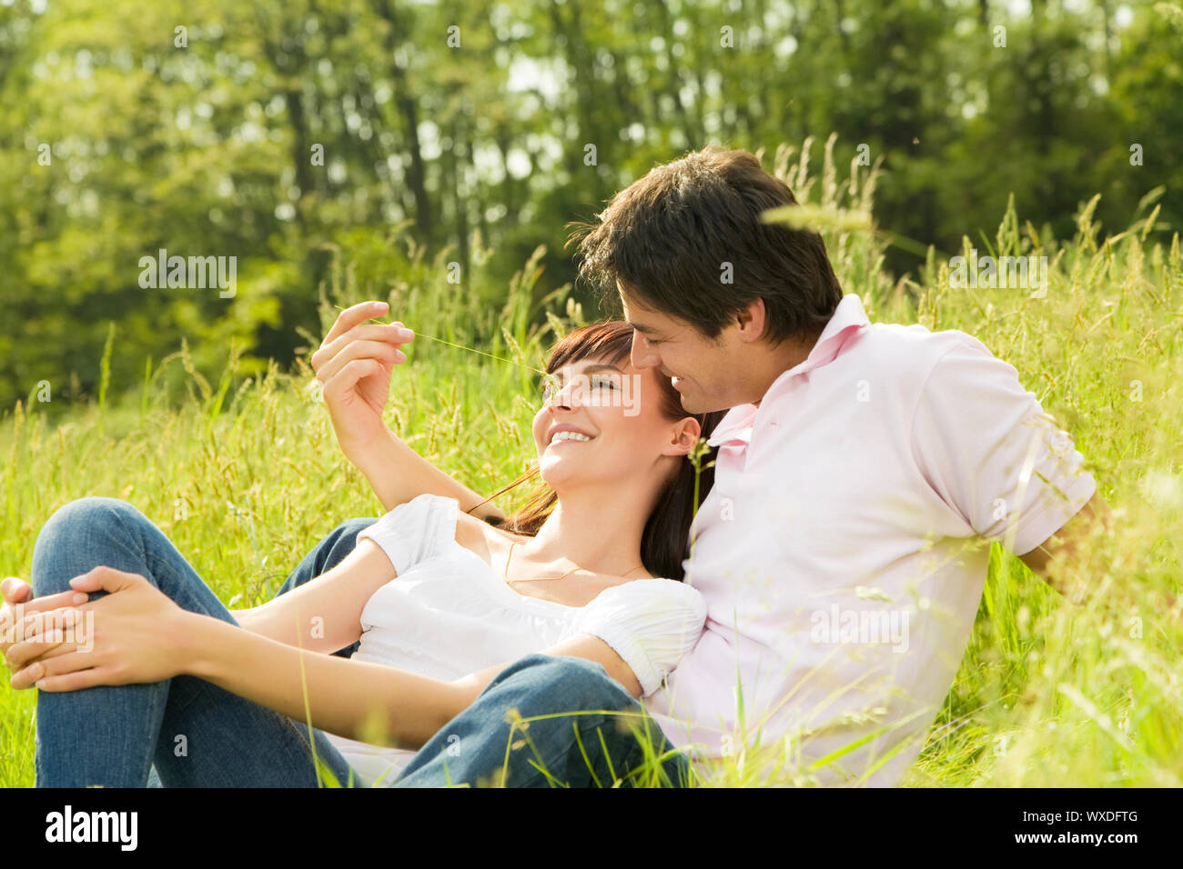 Romance love story. Парень и девушка на траве. Парочка на природе. Пара влюбленная в траве. Парочка лежит на траве.