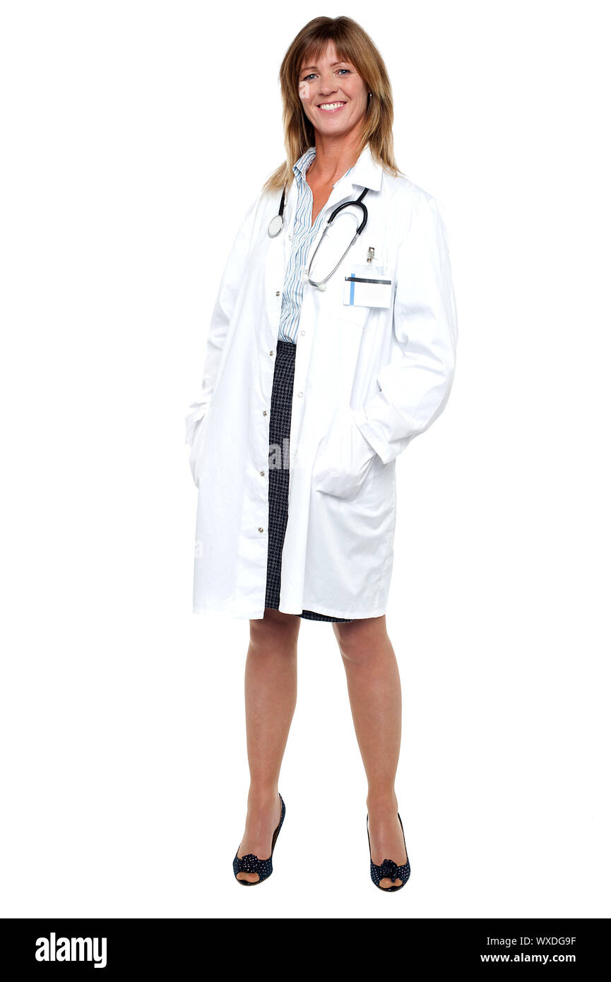 Full length portrait of pretty physician posing with hands in her coat pocket. Stock Photo